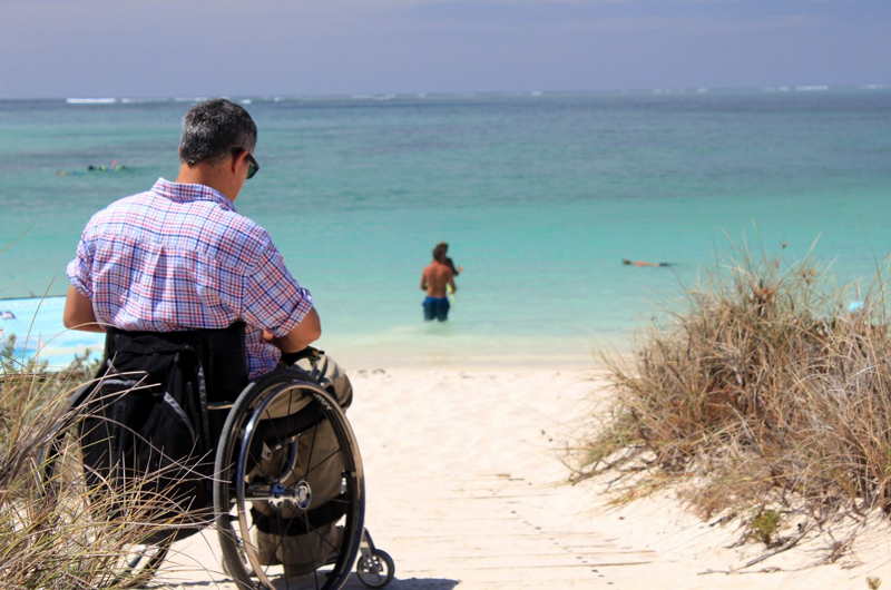 Vacancier en fauteuil roulant au bord de la mer