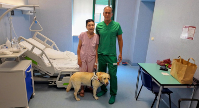 Elena, son chien-guide et le professeur Michel Reibaldi qui l'a opérée