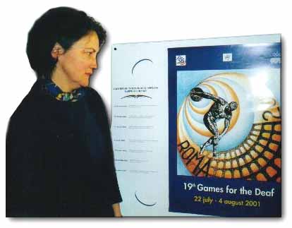 Isabelle Malaurie devant l'affiche des Jeux mondiaux des Sourds 2001.