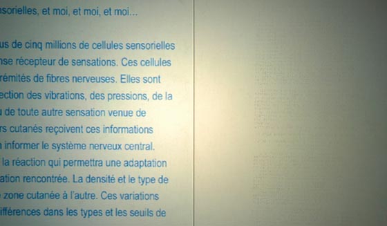 à gauche le texte en noir, à droite son équivalent Braille en relief. Passer les doigts sur le Braille fait défiler le texte noir