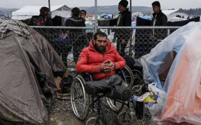 Un homme migrant amputé des deux jambes et en fauteuil roulant - image d'illustration