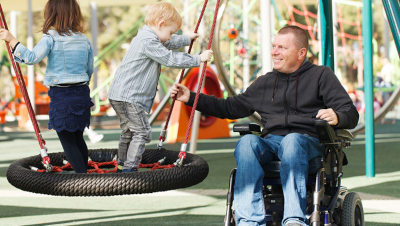 Un père paraplégique et son fils dans un parc public